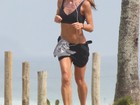 Com short e top, Cynthia Howlett corre na praia