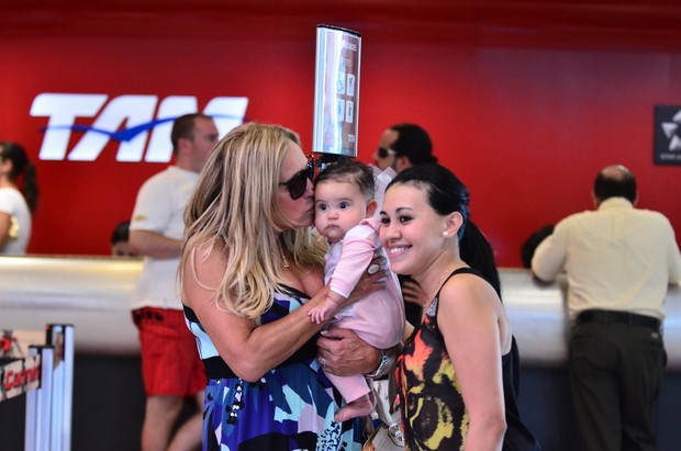 Susana Vieira segura bebê no colo em aeroporto para foto (Foto: William Oda / Agnews)