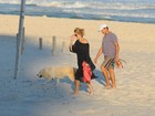 Christine Fernandes passeia em praia com cachorro