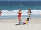 De maiô retrô, Cássia Kis Magro curte praia com os filhos no Rio