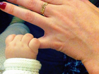 Alinne Moraes posa com a mãozinha do filho segurando seu dedo