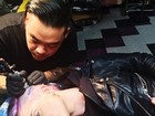 Com cabelo roxo, Kelly Osbourne tatua a cabeça