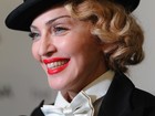 Com look masculino, Madonna vai a première com dente sujo de batom