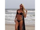 Caroline Bittencourt posa de biquíni na praia e mostra a barriga trincada