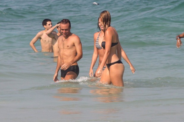 Roger Flores, ex de Deborah Secco, com nova namorada na praia (Foto: Marcos Ferreira / FotoRioNews)