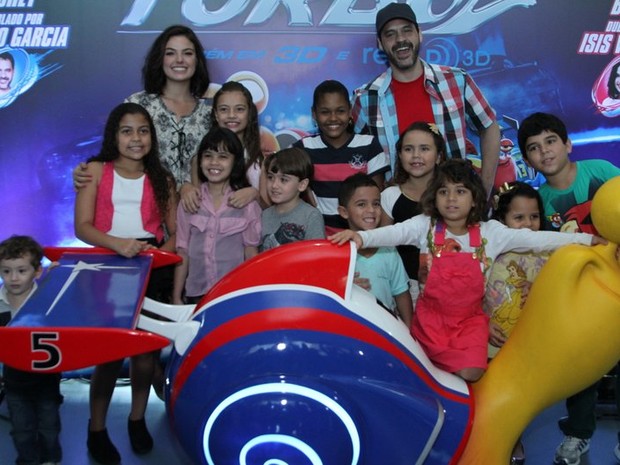 Isis Valverde e Bruno Garcia posam com crianças na pré-estreia de &quot;Turbo&quot; (Foto: Anderson Borde / AgNews)
