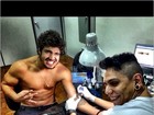 Caio Castro faz careta enquanto faz nova tatuagem 