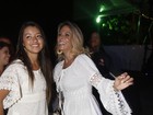 De pernas de fora, Carla Perez e a filha curtem show do Harmonia do Samba