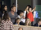 Em estádio, Harper torce pelo pai David Beckham no colo de Victoria 