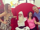 De vestido curtinho, Babi Rossi posa com família e Papai Noel
