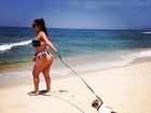 Mulher Melancia vai à praia de fio-dental acompanhada do cãozinho