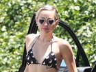 De biquíni e óculos de coração, Miley Cyrus mostra barriga chapada