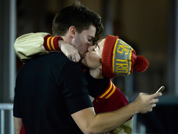 Miley Cyrus e Patrick Schwarzenegger se beijam durante jogo de futebol em Los Angeles, nos Estados Unidos (Foto: Harry How/ Getty Images/ AFP)