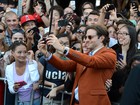 Com os cabelos maiores, Bradley Cooper tira fotos com fãs em première