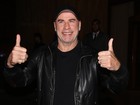 John Travolta acena para fãs na porta de hotel