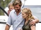 Liam Hemsworth e Kate Winslet caminham abraçados em set 