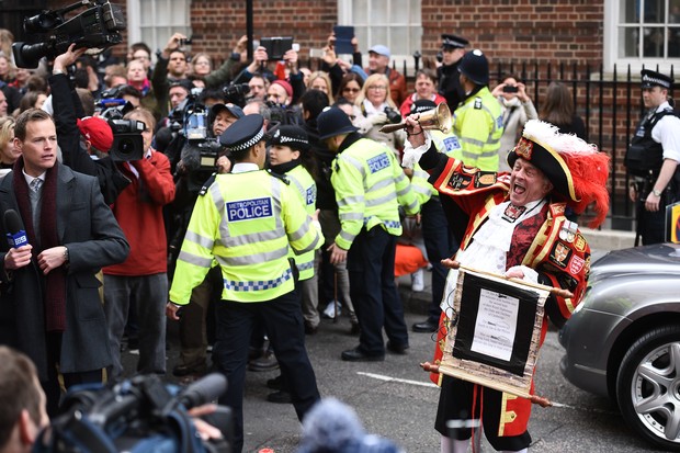 Tony Appleton comemora o nascimento e policiais contém a multidão (Foto: AFP)