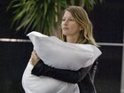 Gisele Bündchen usa um travesseiro para carregar a filha em aeroporto