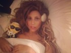 Lady Gaga posa deitada na cama enrolada em lençol