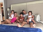 Dentinho posa na cama com Dani Souza e os filhos 