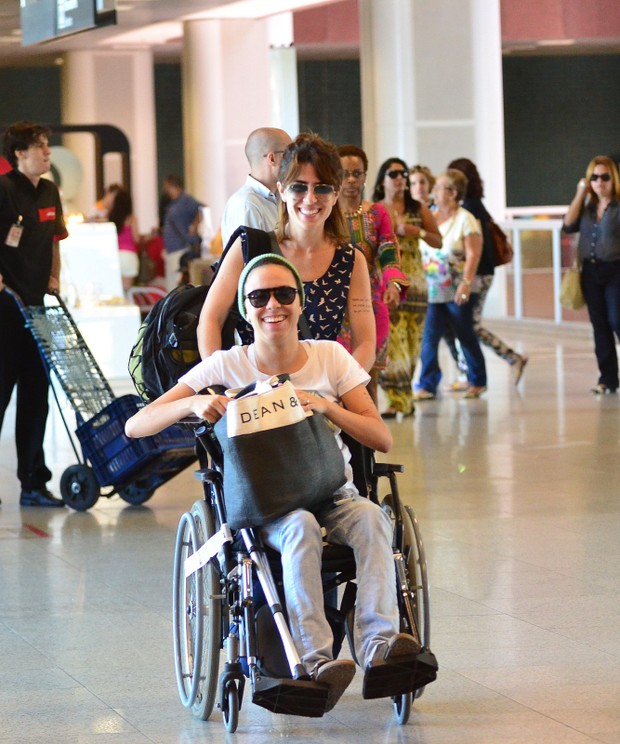 De cadeira de rodas, Maria Gadu embarca com namorada no aeroporto (Foto: FotoRioNews / William Oda)