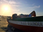 Camila Queiroz relaxa em proa de barco durante passeio em praia