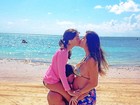 Na praia, ex-BBB Rodrigo beija a barriga da mulher, grávida