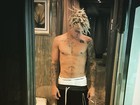 Justin Bieber posa sem camisa e com cigarro na mão