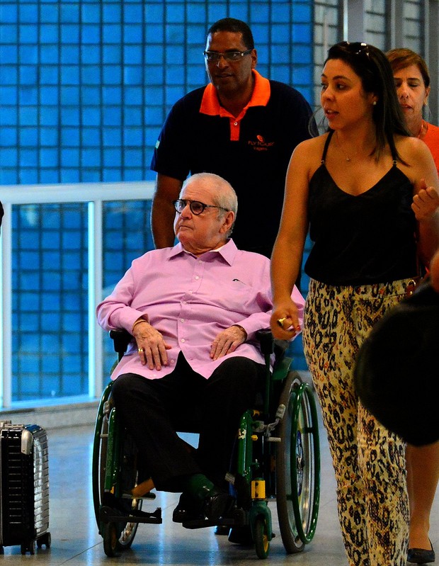 Jô Soares de cadeira de rodas no aeroporto (Foto: William Oda/Agnews)