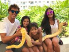 Aline Riscado posa com Felipe Roque e filho segurando cobra gigante