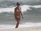 Christine Fernandes desfila pela praia com biquíni branco