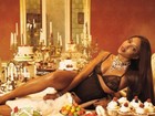 De lingerie, Naomi Campbell aparece em cima da mesa com banquete