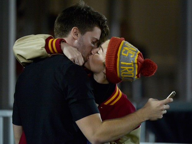 Miley Cyrus e Patrick Schwarzenegger se beijam durante jogo de futebol em Los Angeles, nos Estados Unidos (Foto: Harry How/ Getty Images/ AFP)