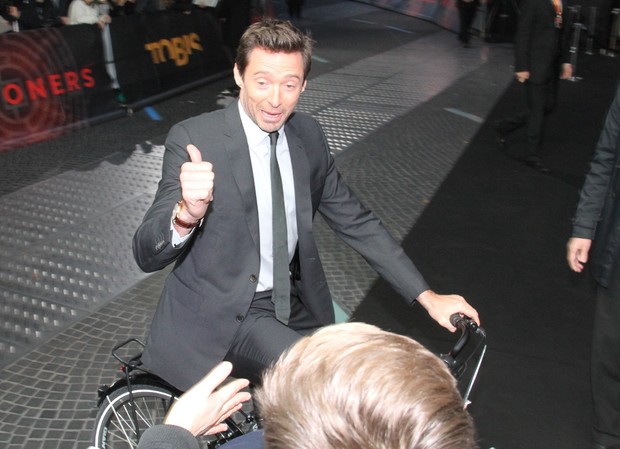 Hugh Jackman chega de bicicleta em premièr  (Foto: Splash News / AKM-GSI )