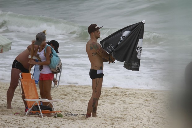 Felipe Titto e namorada na praia da Barra da Tijuca, RJ (Foto: Dilson Silva / Agnews)