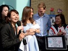 Sósias do príncipe William e de Kate Middleton posam em frente a hospital
