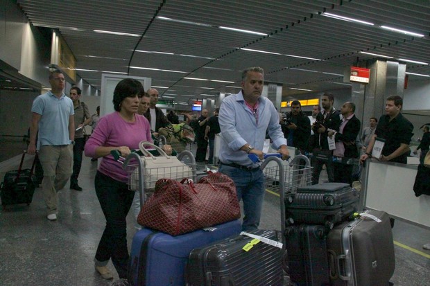 Glória Pires desembarca cheia de malas ao lado do marido, Orlando Morais (Foto: Gabriel Rangel e Delson Silva/Ag News)
