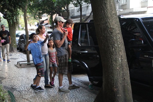 Márcio Garcia coloca as crianças no carro (Foto: Rodrigo dos Anjos/Agnews)