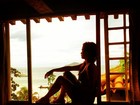 De férias, Nanda Costa relaxa e aparece sentada em janela