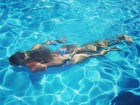 Adriane Galisteu ameniza o calor da Itália com mergulho na piscina
