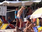 Letícia Birkheuer se descuida e mostra demais em praia com o filho