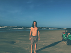 Tiago Iorc aparece de cabelos soltos e sem camisa em praia