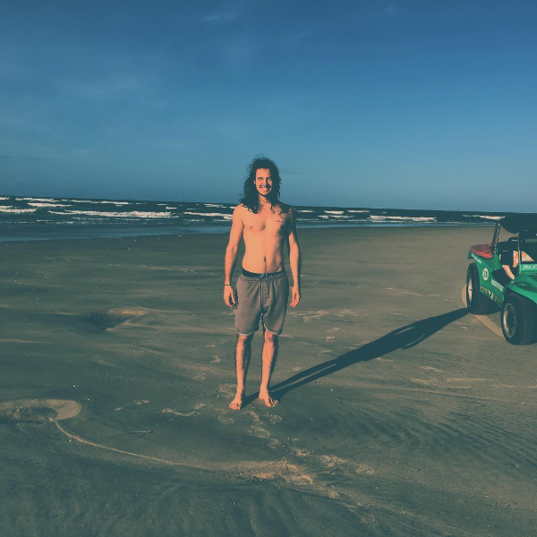 Tiago Iorc aparece de cabelos soltos e sem camisa em praia (Foto: Reprodução/Instagram)