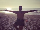 Priscila Pires faz posição da ioga na praia 