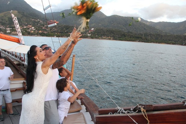 Alexandre e Fabiana Frota jogam flores no mar junto com Enzo (Foto: Rodrigo dos Anjos/Ag News)