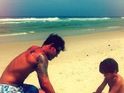 Juliano Cazarré brinca com o filho na areia da praia